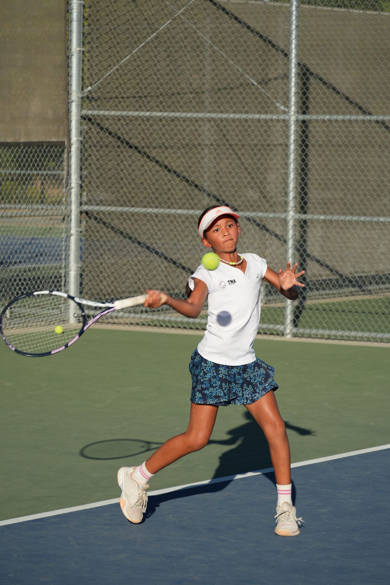 A junior TNA Pro Academy player in a TNA shirt hitting a forehand