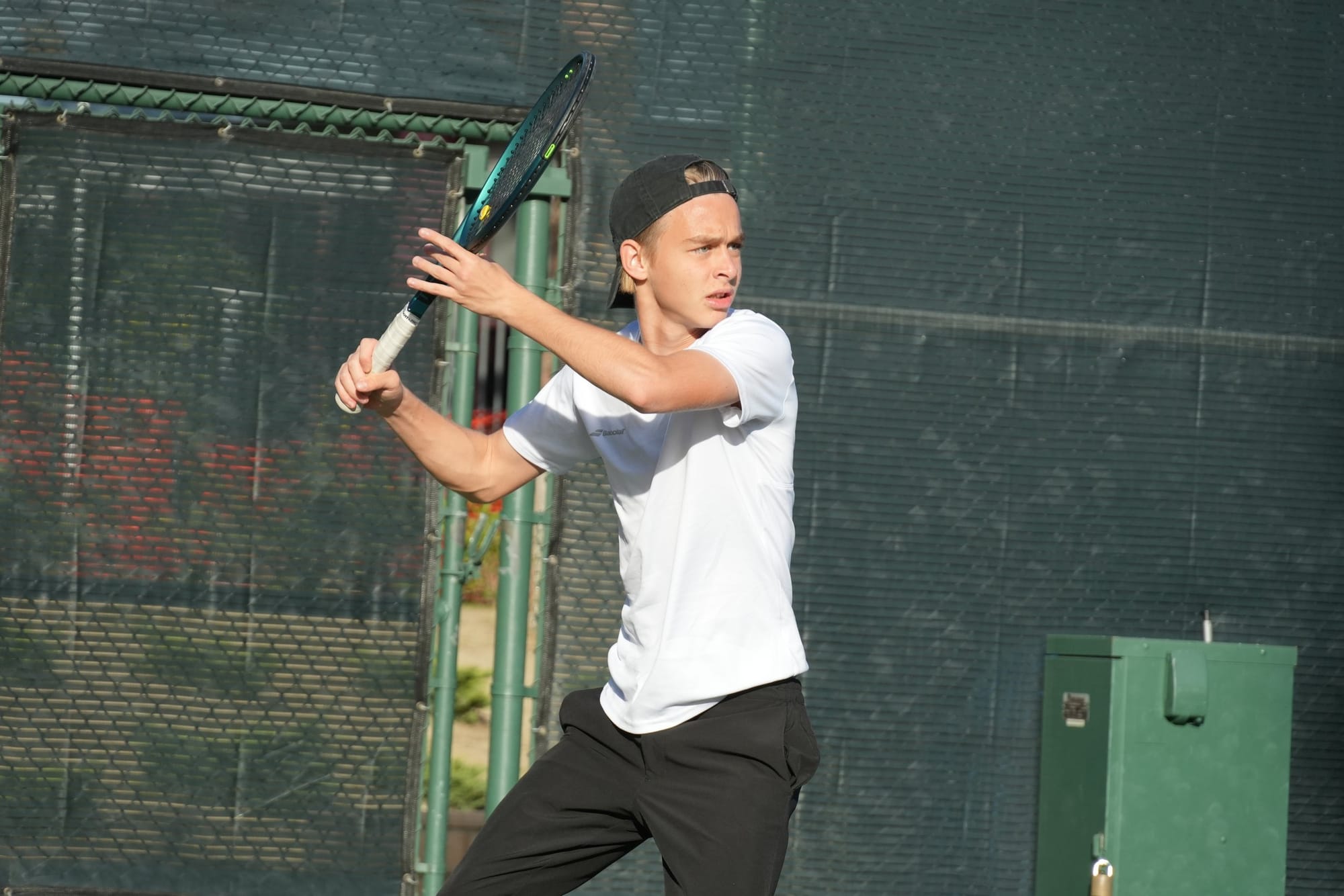 A high-performance tennis player preparing a backhand in training